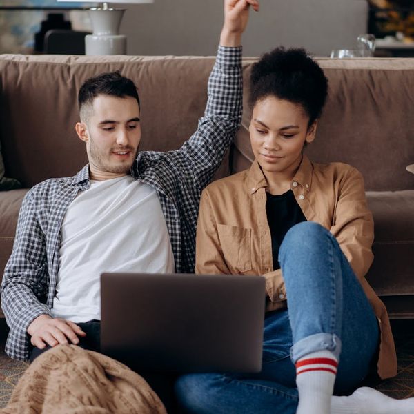 Smiling person stretching near a work desk at home.
